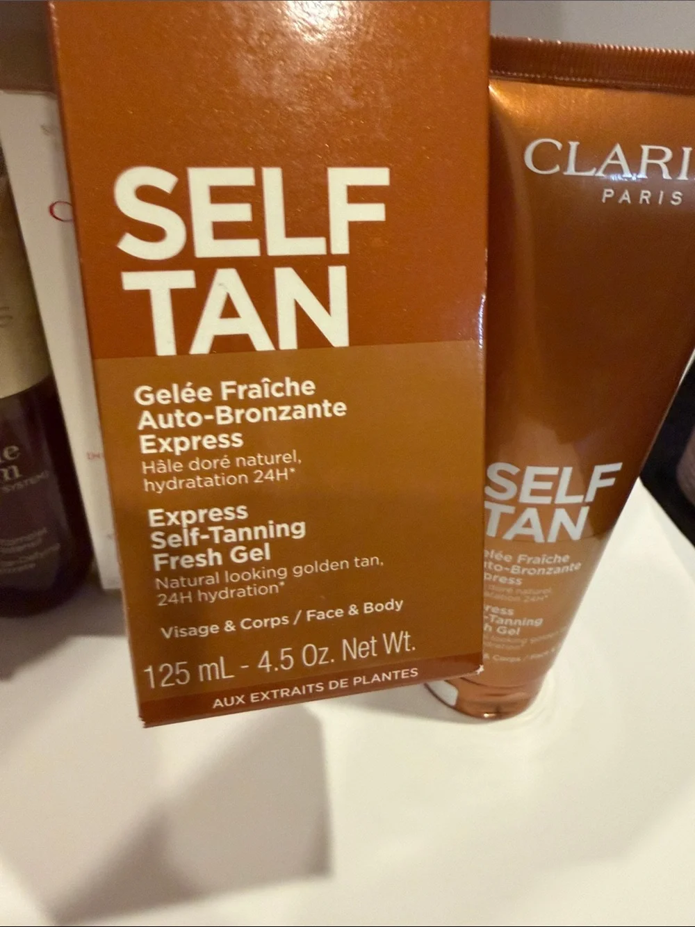 Clarins skincare set in pink, gold, white, and bronze